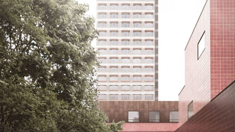 Ett högt flerbostadshus som skyms lite av ett stort träd.
